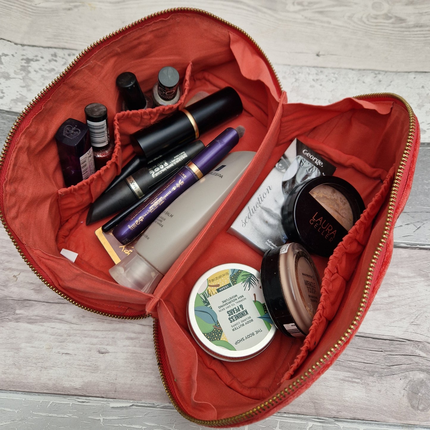 Inside view of a folded open vanity case full of make up.