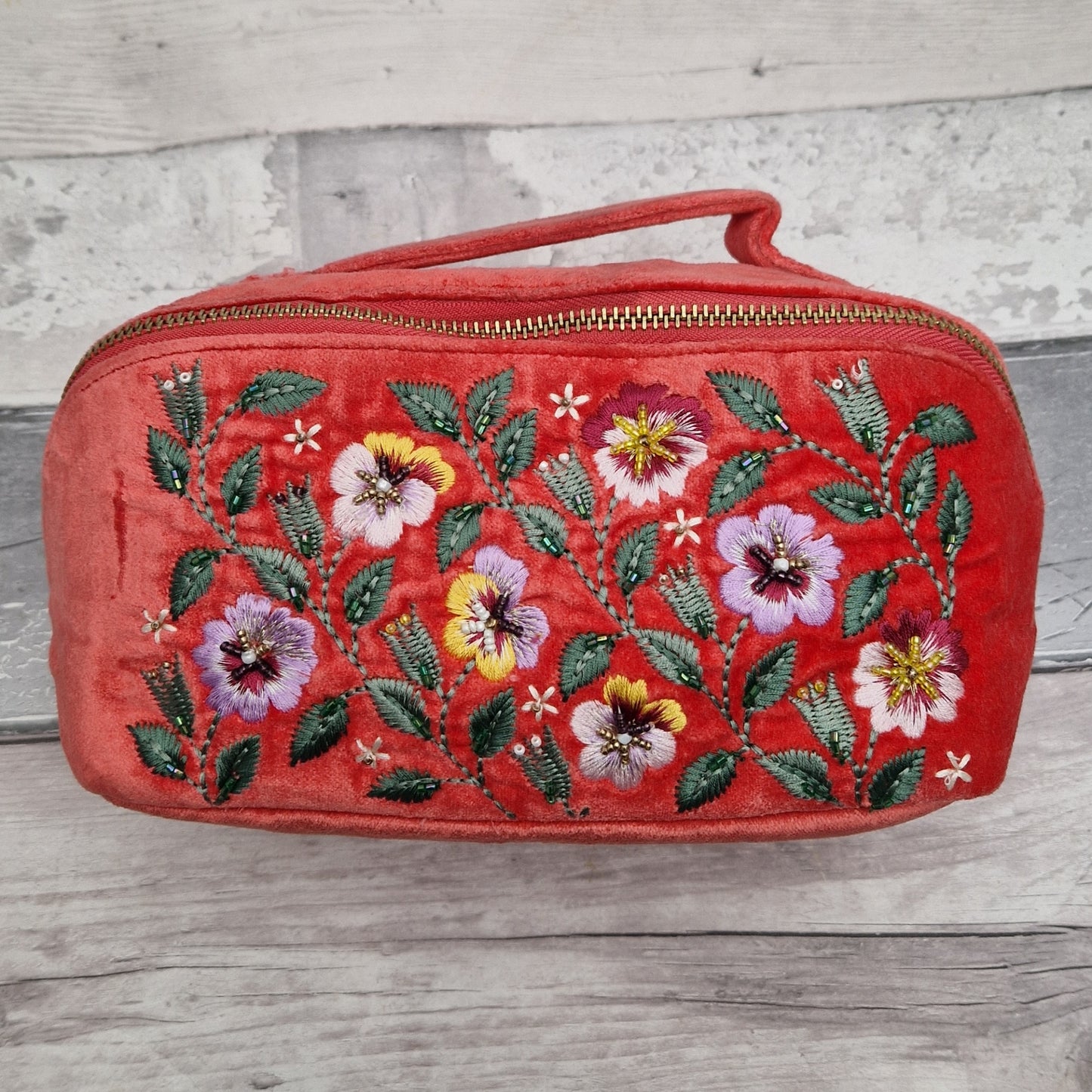 Salmon coloured velvet vanity case decorated with an embroidered scene of yellow and purple pansies.