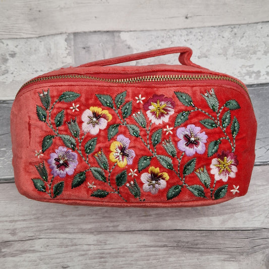 Salmon coloured velvet vanity case decorated with an embroidered scene of yellow and purple pansies.
