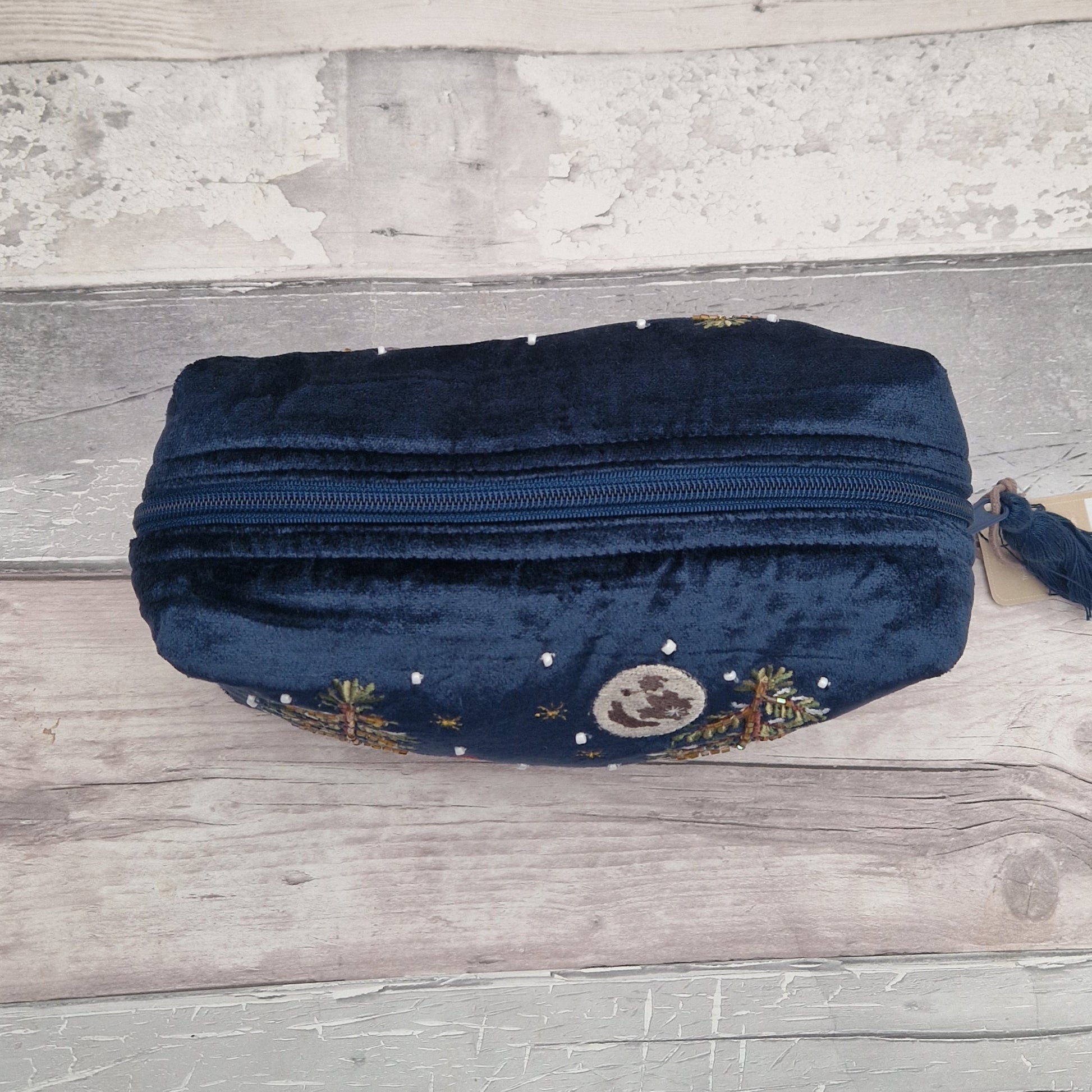 Top down view of a navy velvet washbag with zip closer.