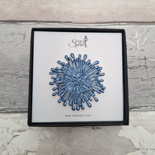 Magnetic Brooch shaped like a blue frework explosion.