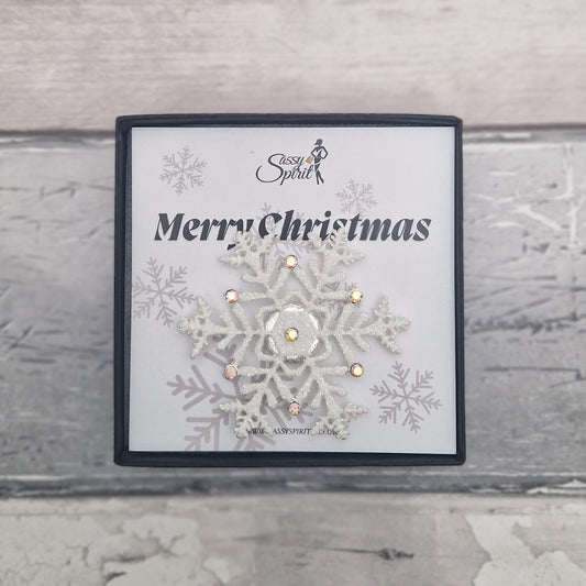 White snowflake magnetic brooch presented in a gift box with a Merry Christmas card.
