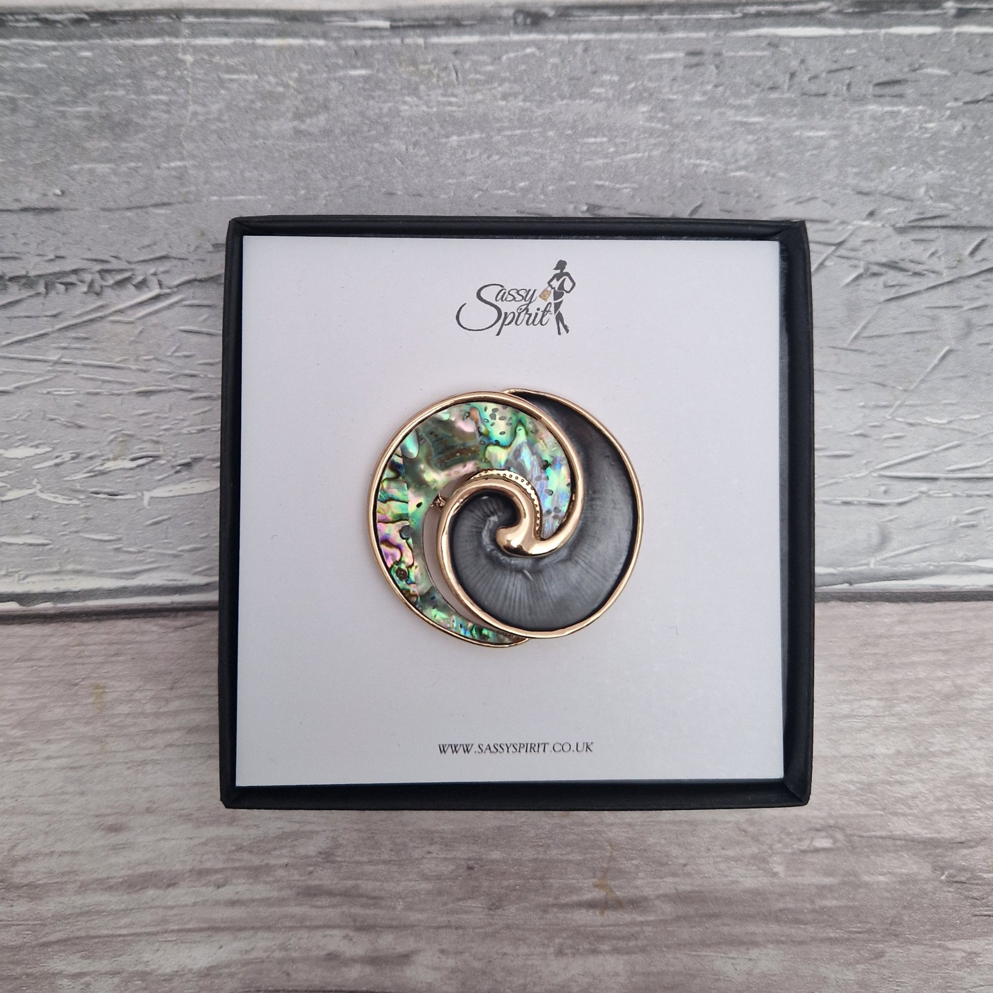 New Zealand Paua Shell decorates the swirl shaped magnetic brooch, presented in a black gift box.