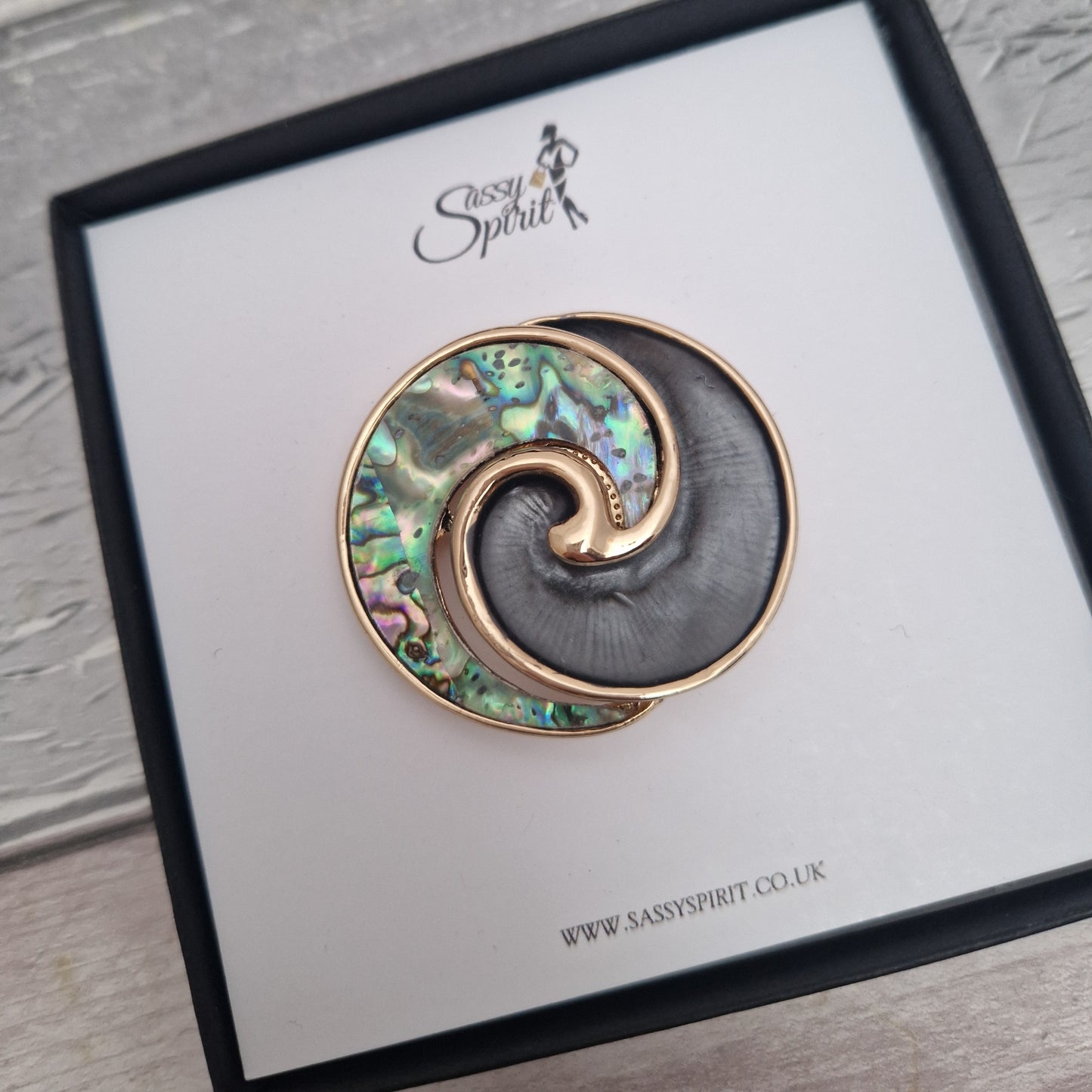 New Zealand Paua Shell swirl shaped brooch in a black gift box.