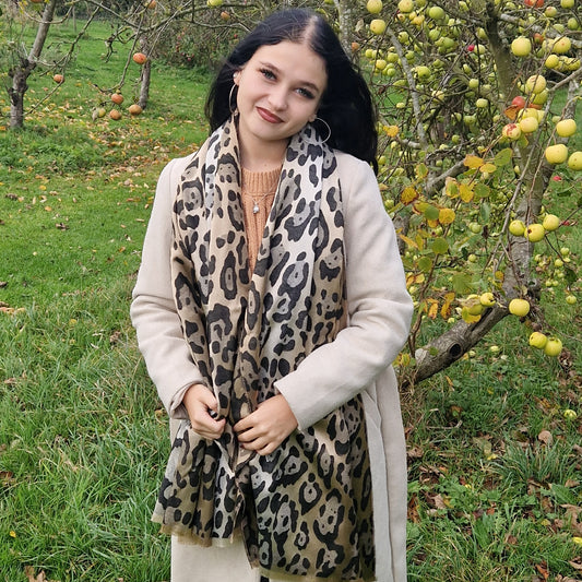 Young Woman wearing a leopard print scarf in an apple orchard