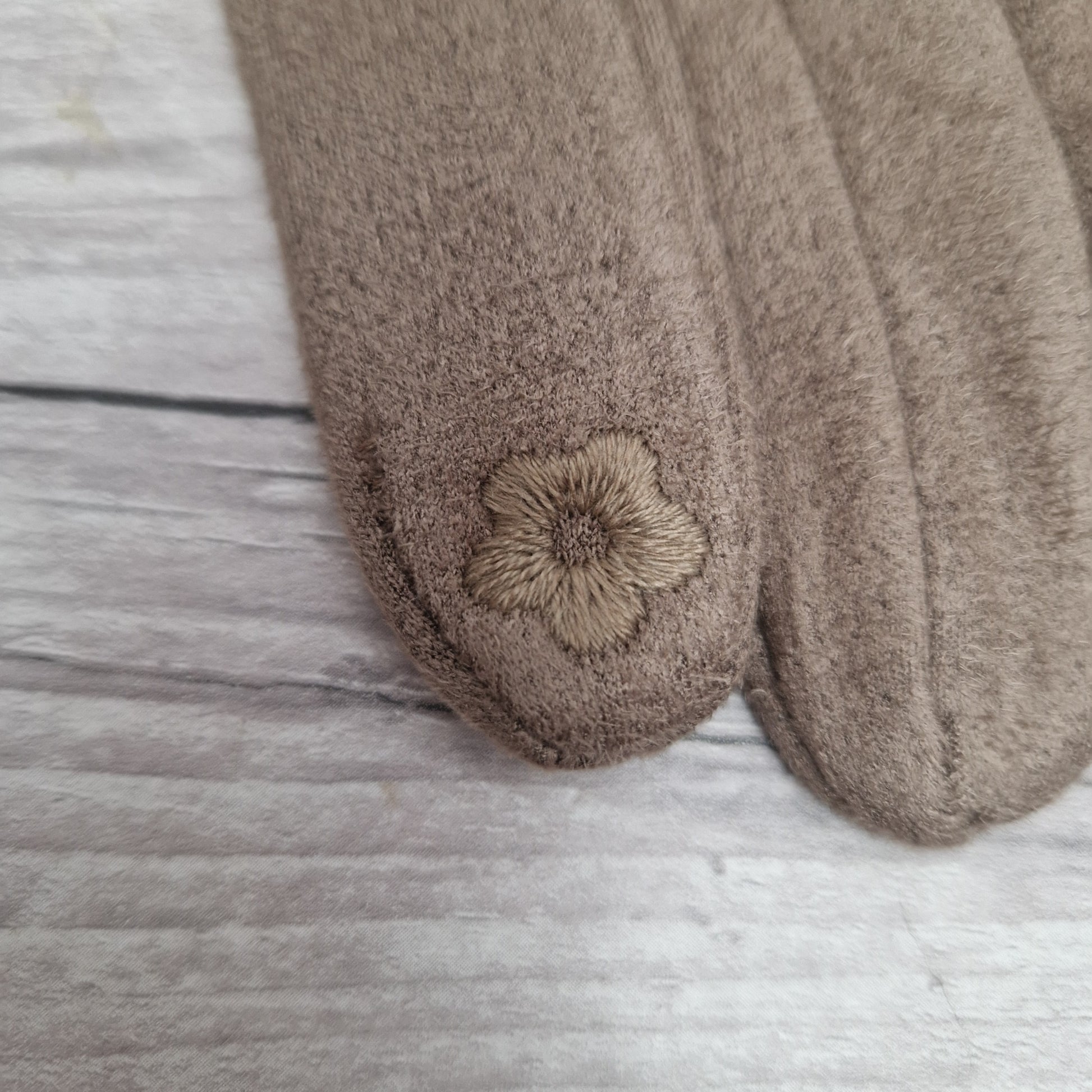 Daisy phone finger digit on a brown pair of gloves.