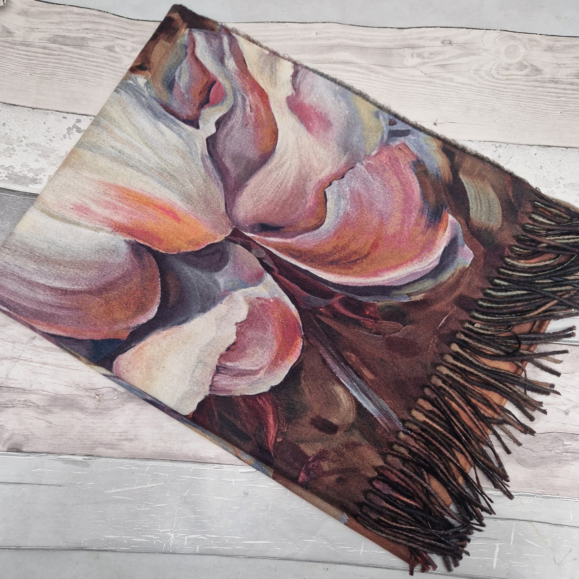 Colorful scarf with fringes on a wooden surface