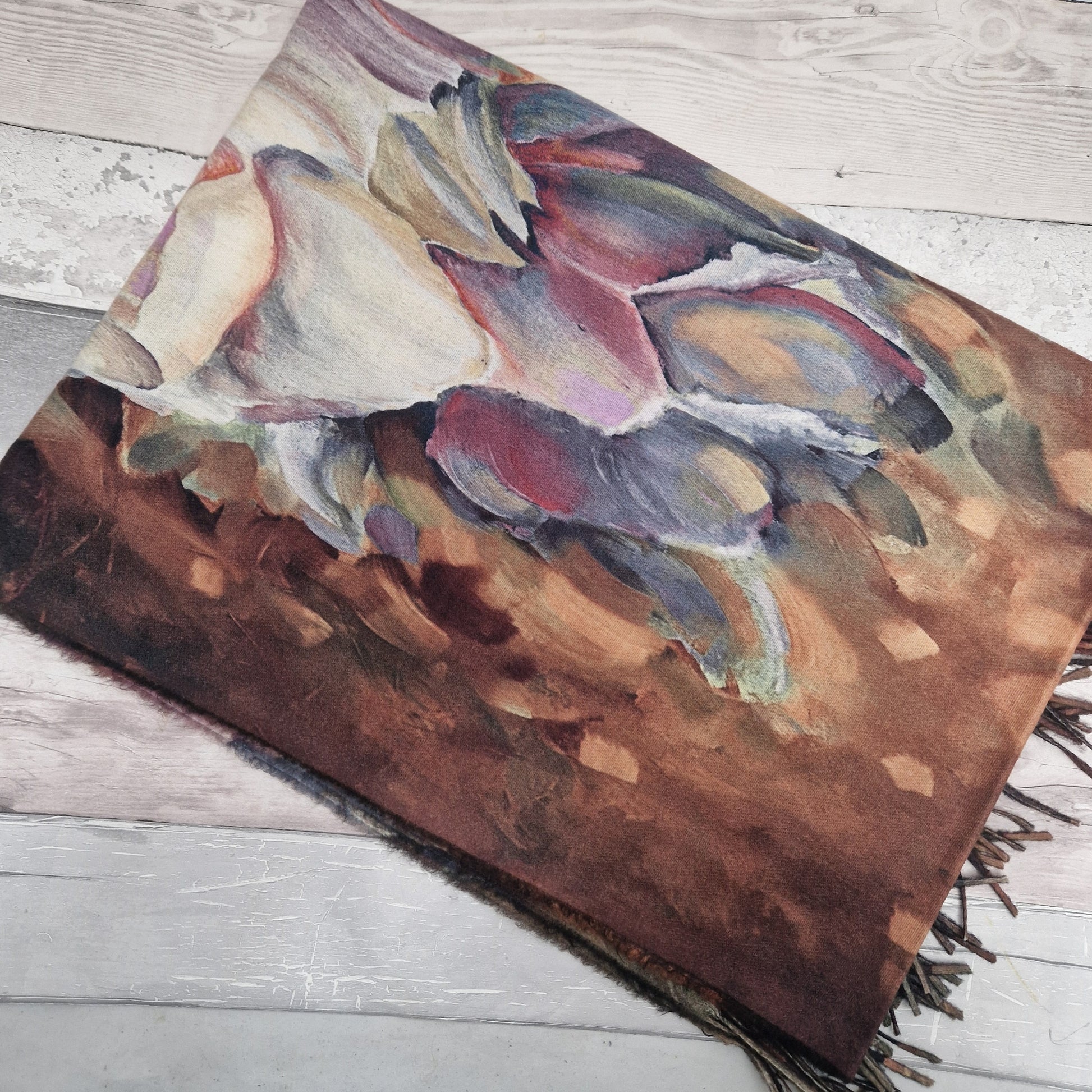Colorful scarf with fringes on a wooden surface