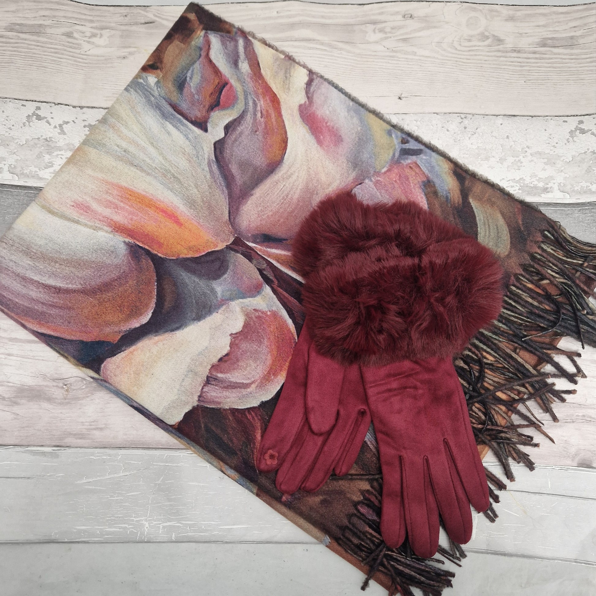 Colorful scarf with fringes on a wooden surface