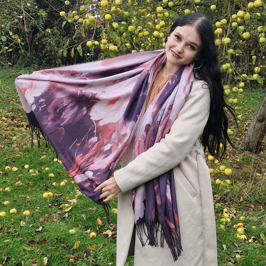 Young Woman wearing a floral scarf in an outdoor setting with greenery and fruit trees.