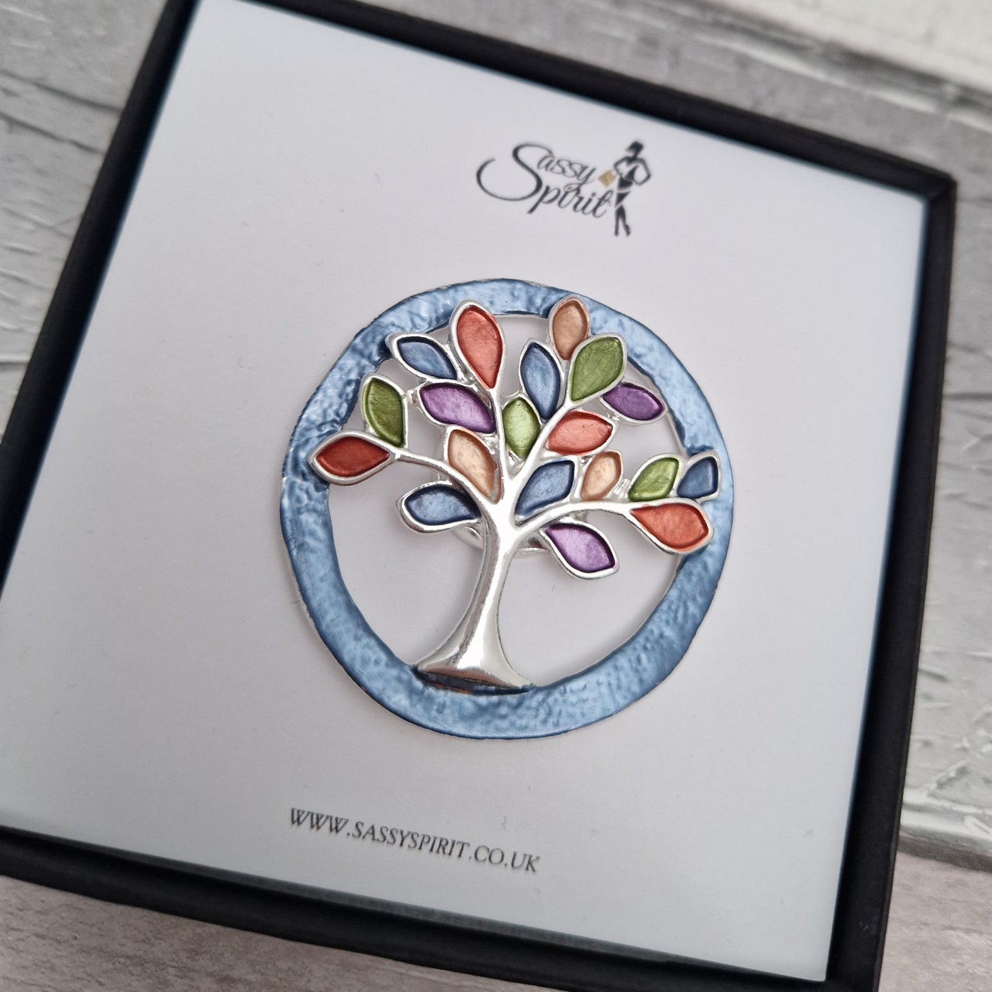 Tree-shaped brooch on a branded card with 'Sassy Spirit' logo.