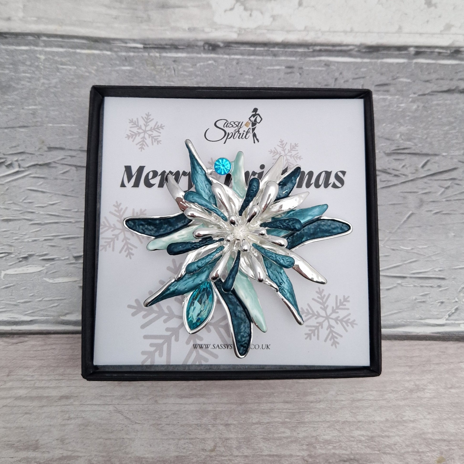Decorative brooch in a 'Merry Christmas' box with a snowy background