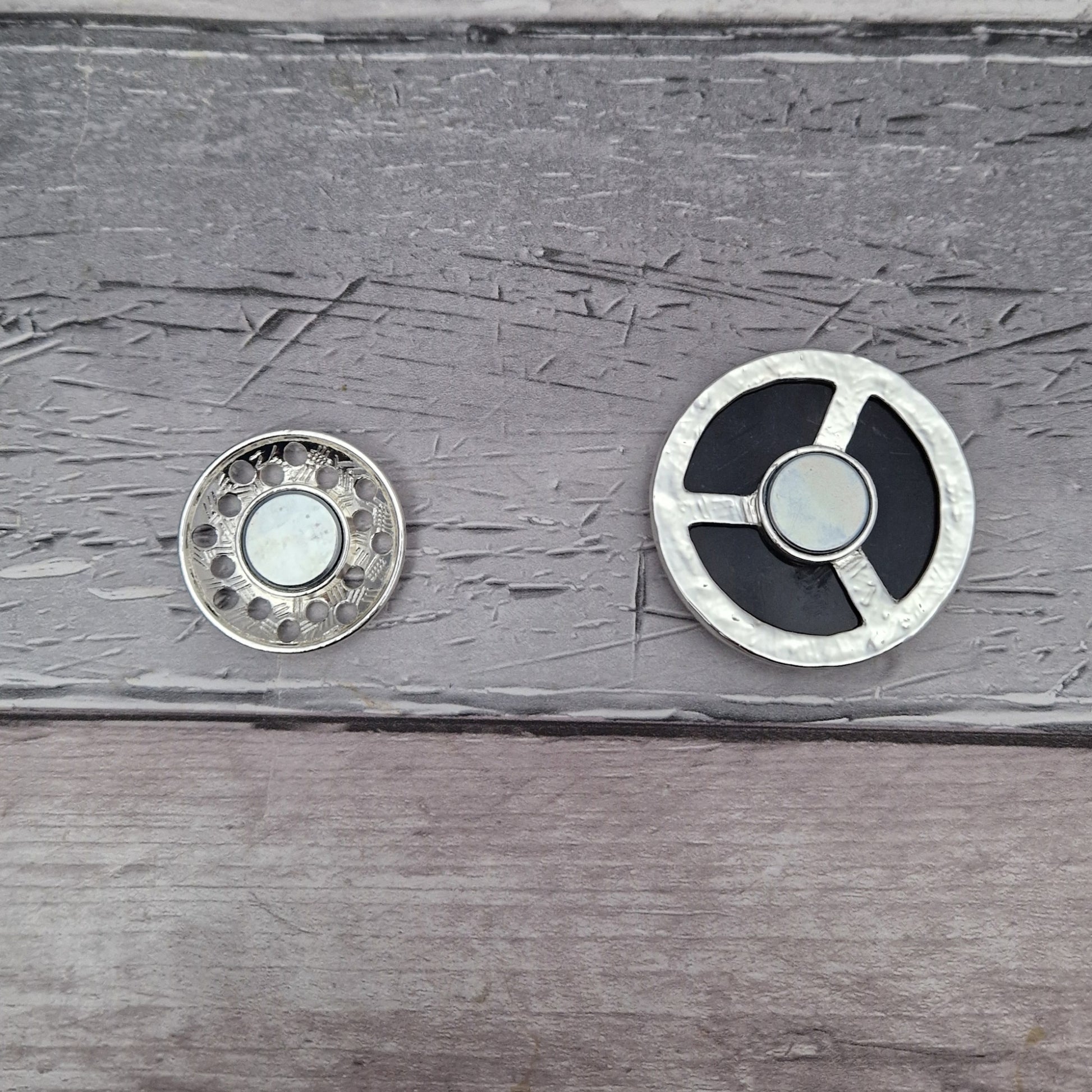 Back face of a metallic brooch in 2 pieces.