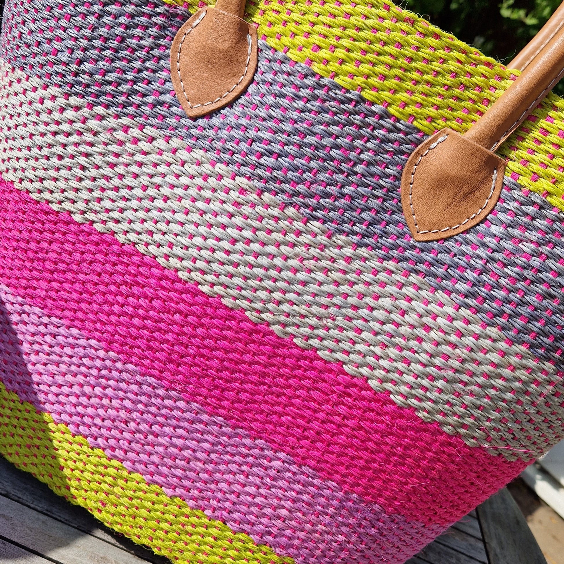 Basket made from Sisal palm decorated in cheerful stripes of pink, lime, lavender and grey