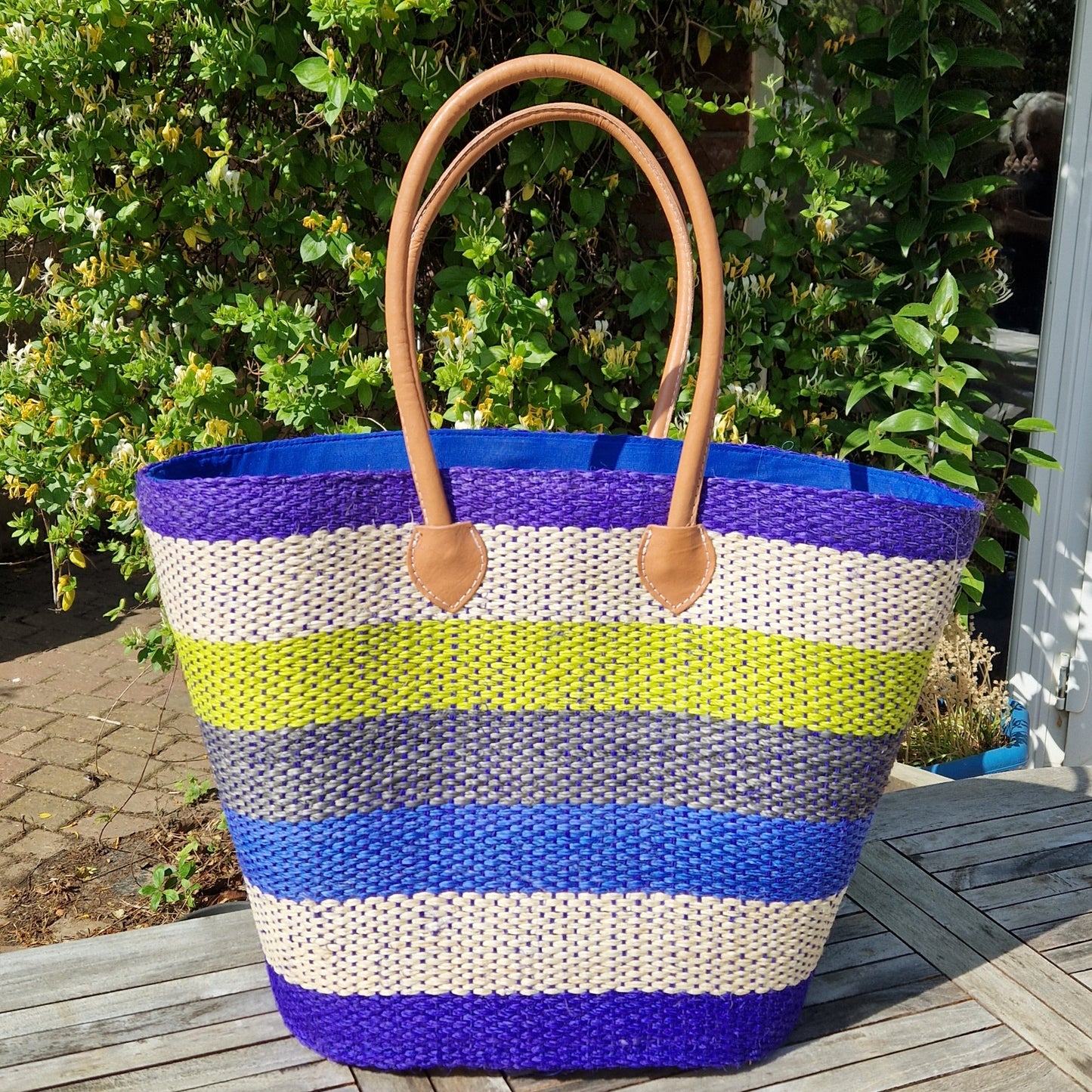 Sisal palm basket with stripes of ocean colours in blue and green.