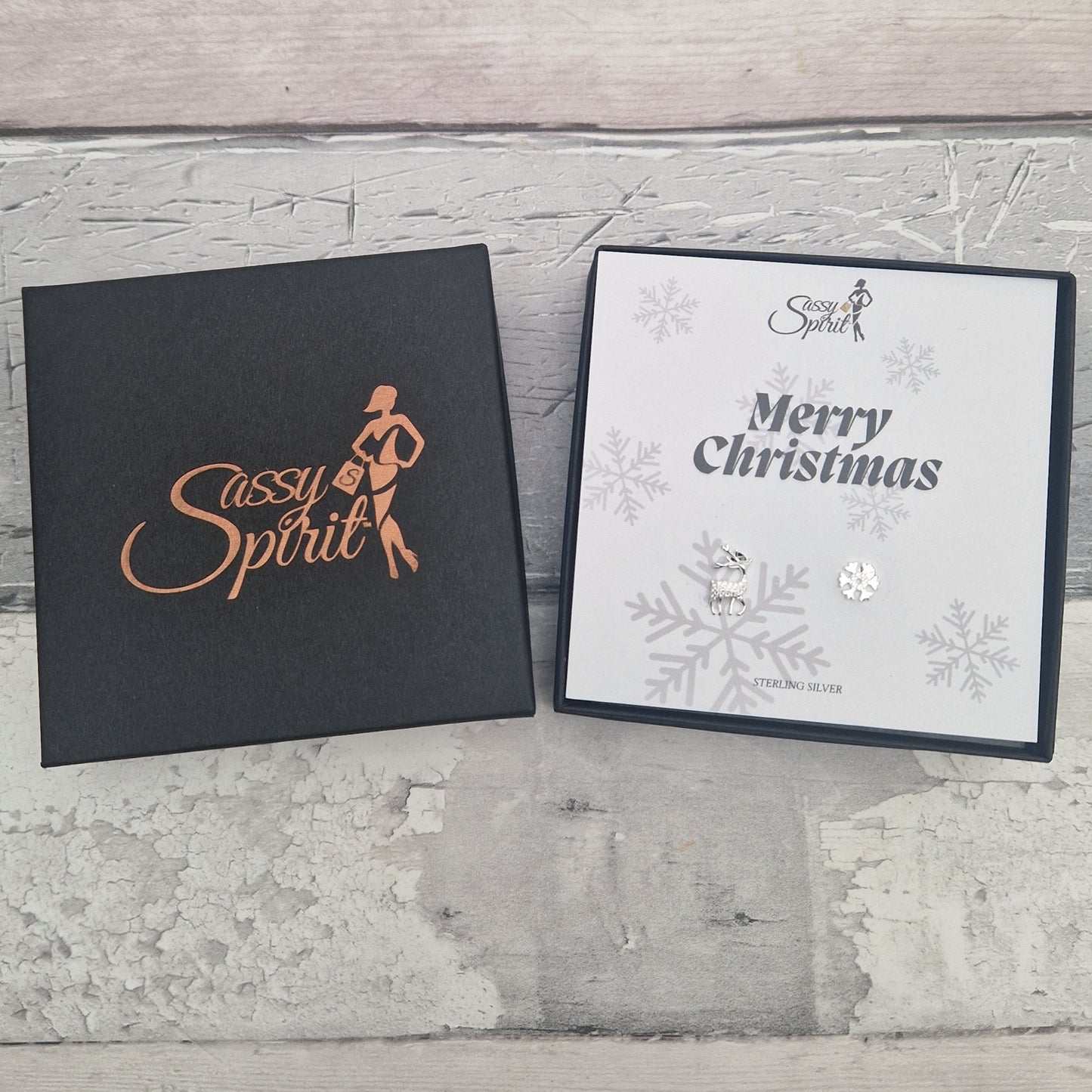 Gift boxed Reindeer and Snowflake sterling silver earrings with 'Sassy Spirit' logo and 'Merry Christmas' text.
