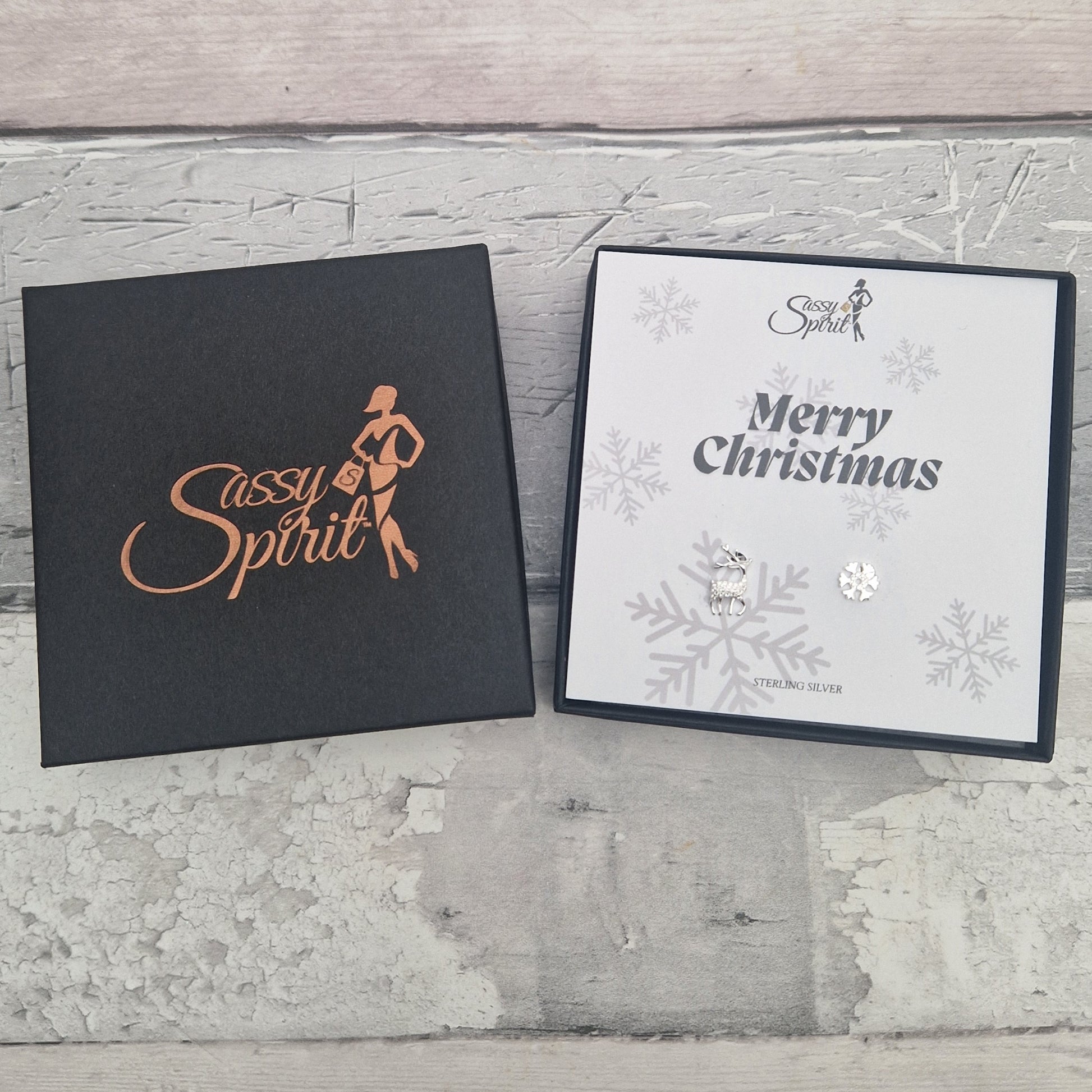 Gift boxed Reindeer and Snowflake sterling silver earrings with 'Sassy Spirit' logo and 'Merry Christmas' text.