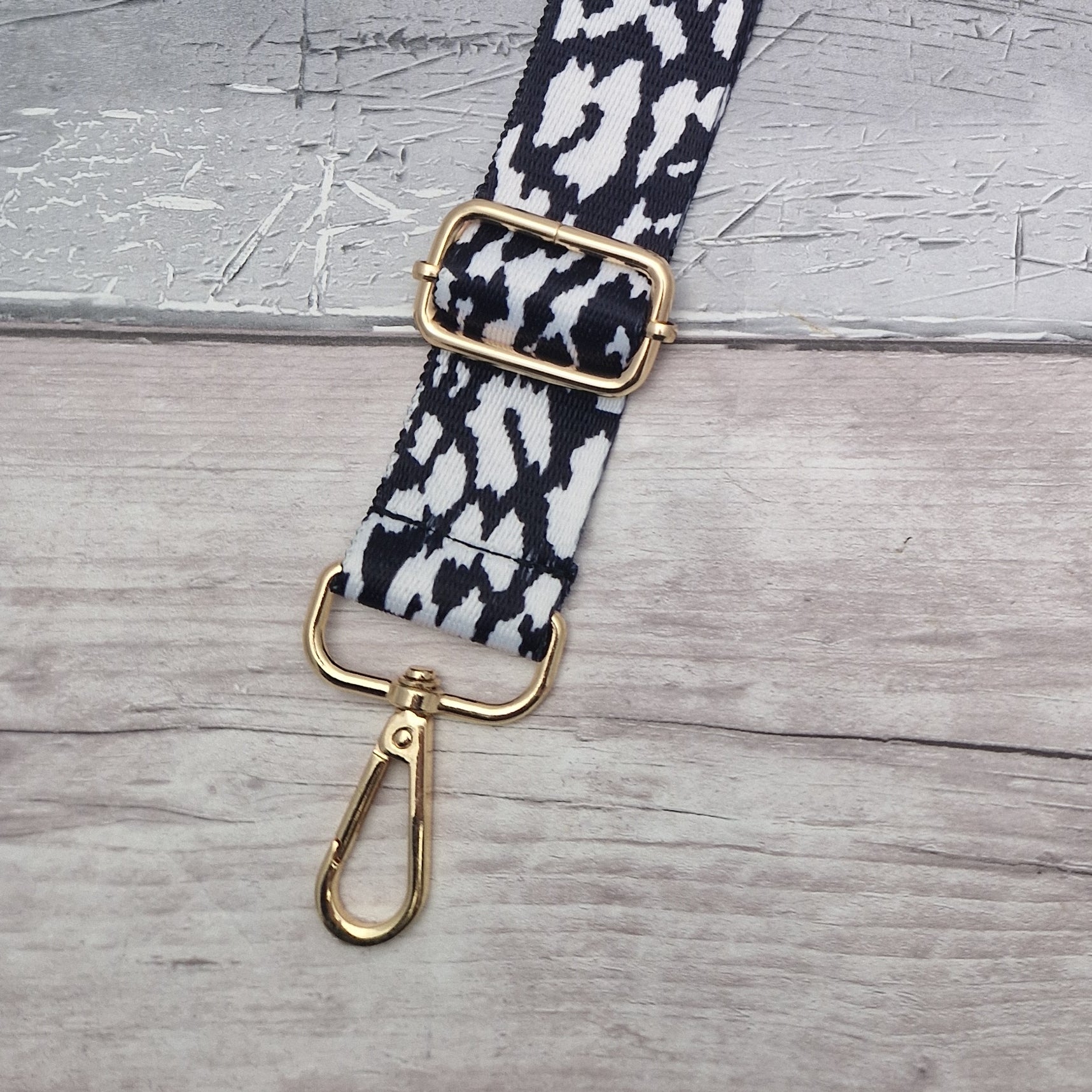 Black and White print bag strap with gold metal work.