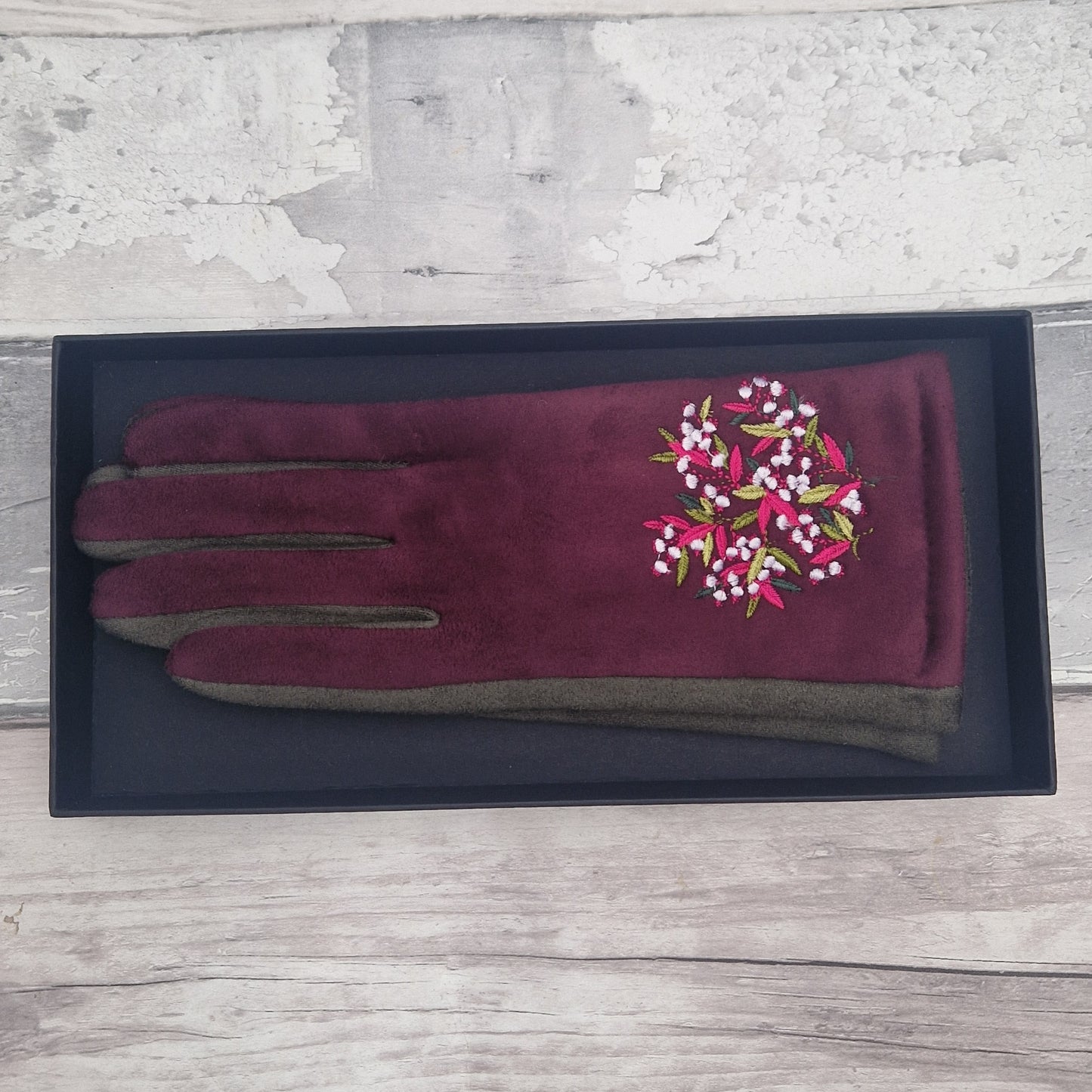Burgundy gloves with embroidered floral design in presentation gift box.