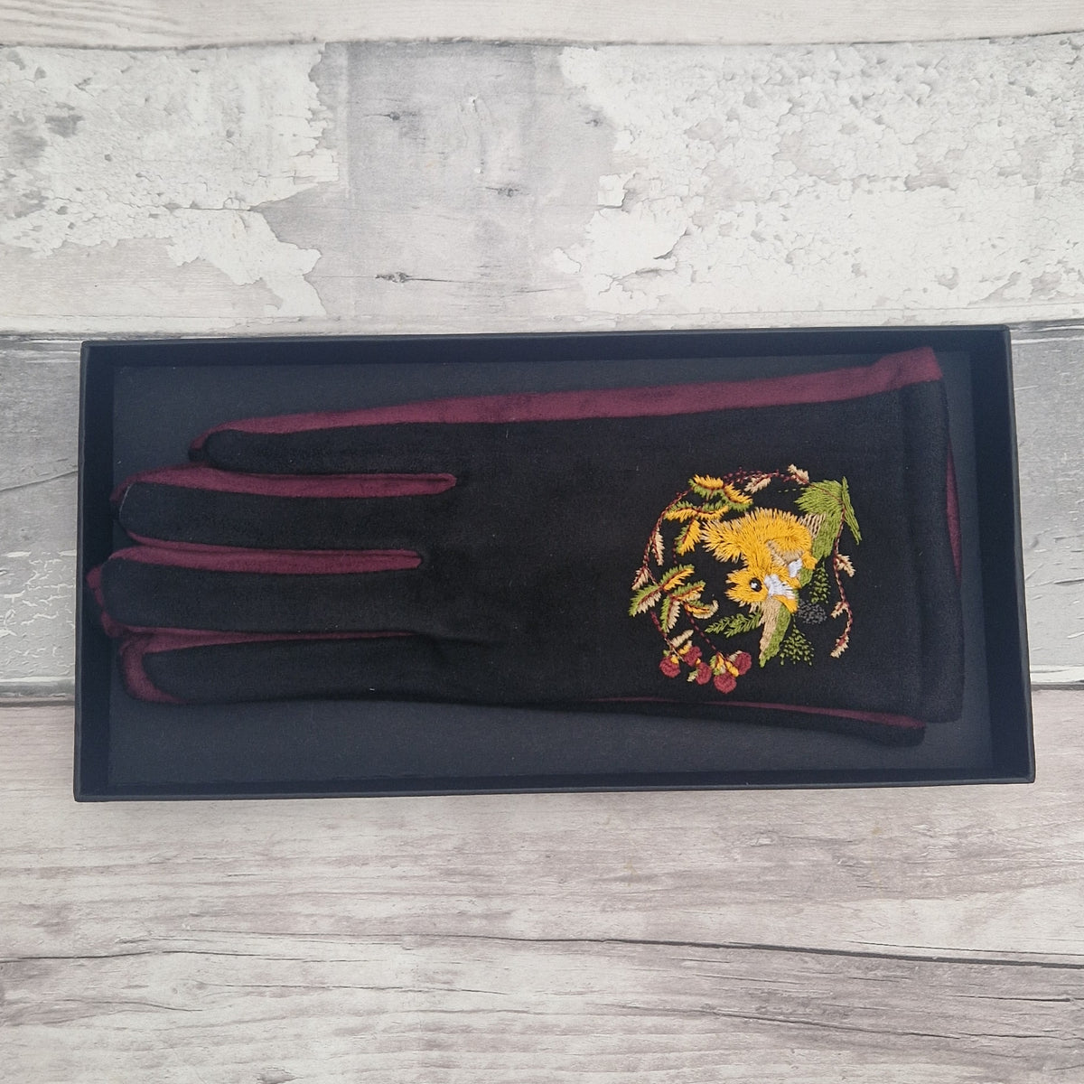Black gloves with embroidered red squirrel design in presentation gift box.