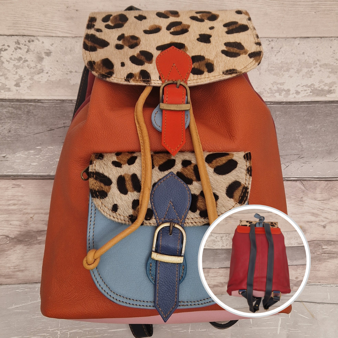 Multicolored backpack made from leather with front pocket and magnetic buckle closers. Orange and blue colours will leopard print panels.