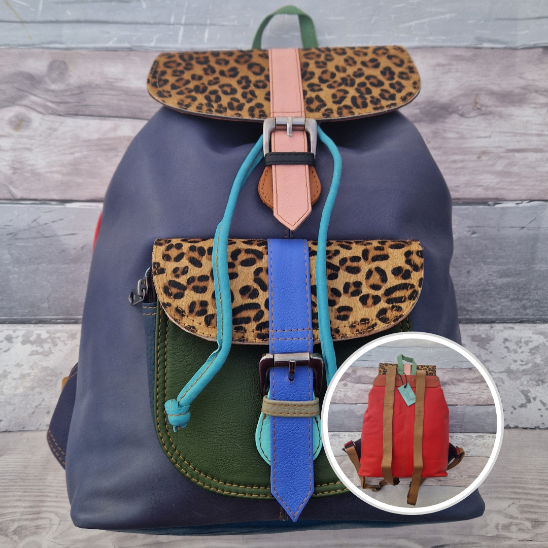 Multicolored backpack made from leather with front pocket and magnetic buckle closers. Lavender and blue colours with textured leopard print panels.
