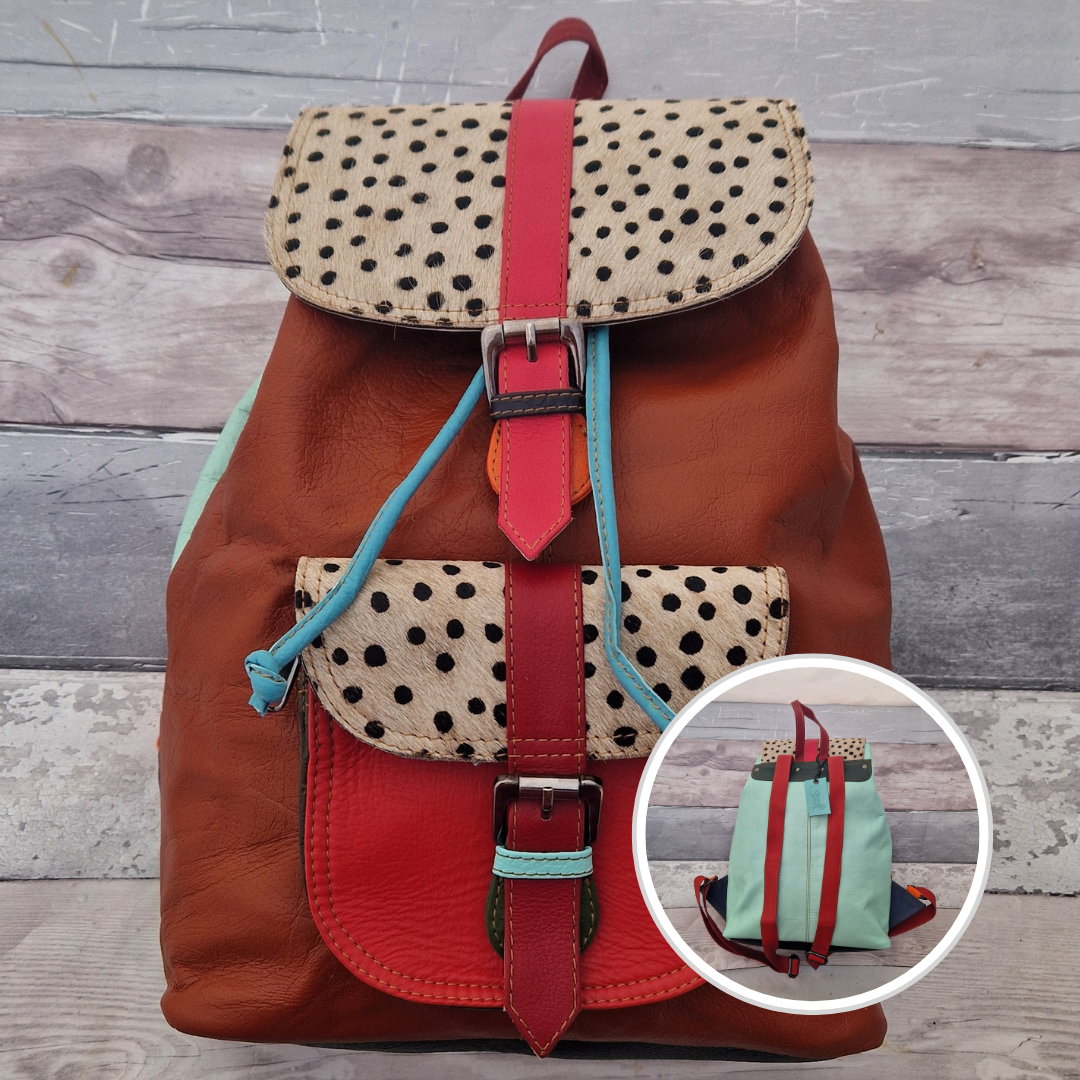 Multicolored backpack made from leather with front pocket and magnetic buckle closers. Rust and red colours with textured spot print panels.