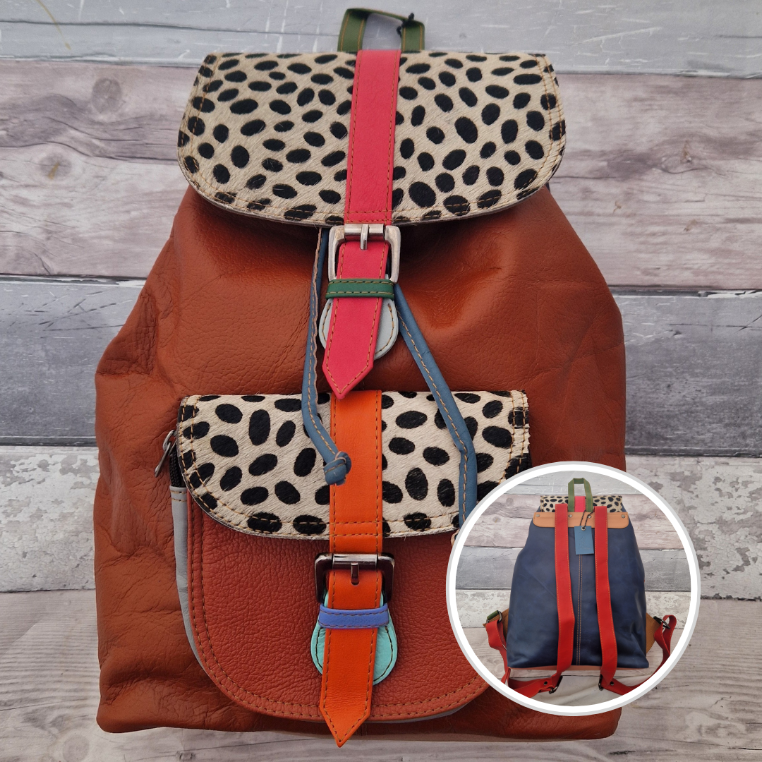 Multicolored backpack made from leather with front pocket and magnetic buckle closers. Rust, orange and blue colours with textured panels of black and white spot print.