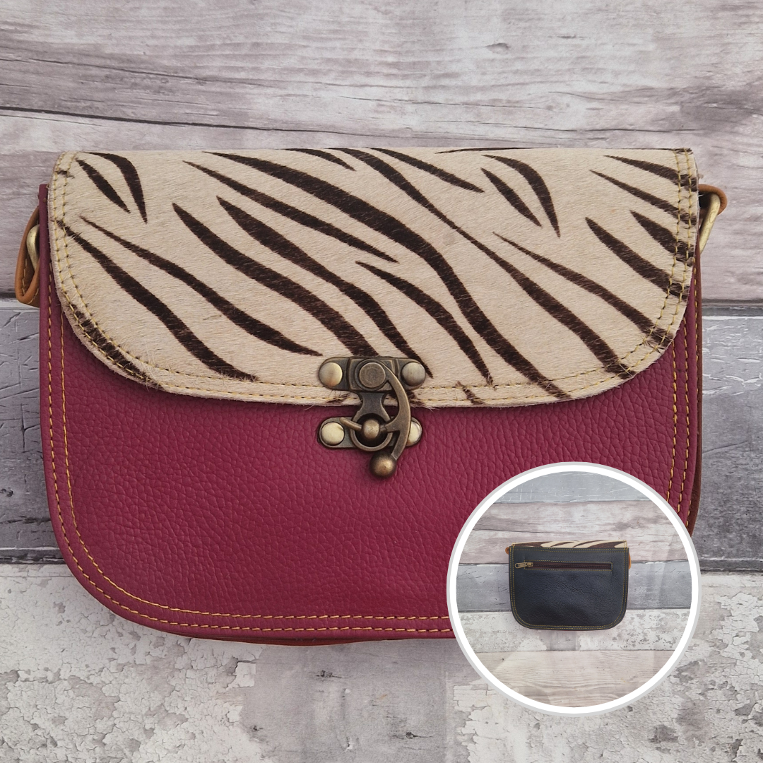 All leather raspberry coloured bag with a textured panel of zebra animal print. A brass swivel clasp secured the bag at the front.