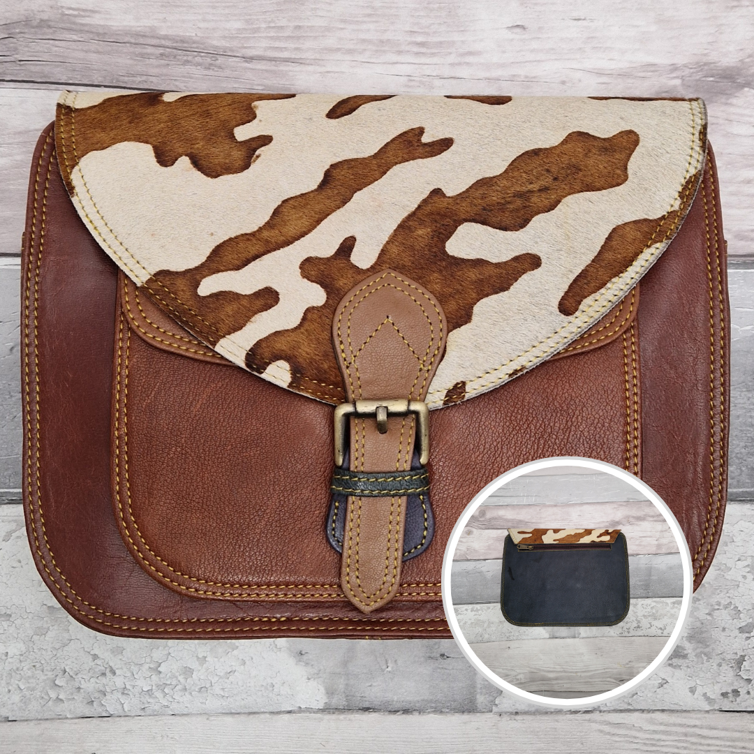 Large Saddlebag style leather crossbody bag. Multicoloured panels of brown finished with a cow print textured flap.