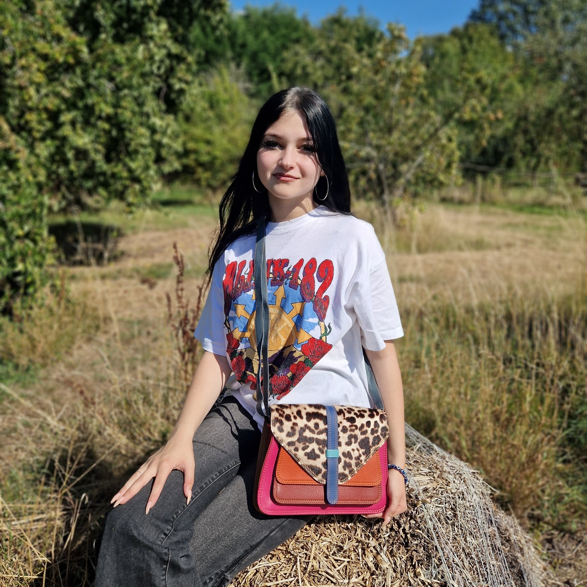 Model with Sassy Spirit Yamini all leather bag in a pink finish with an ocelot print.