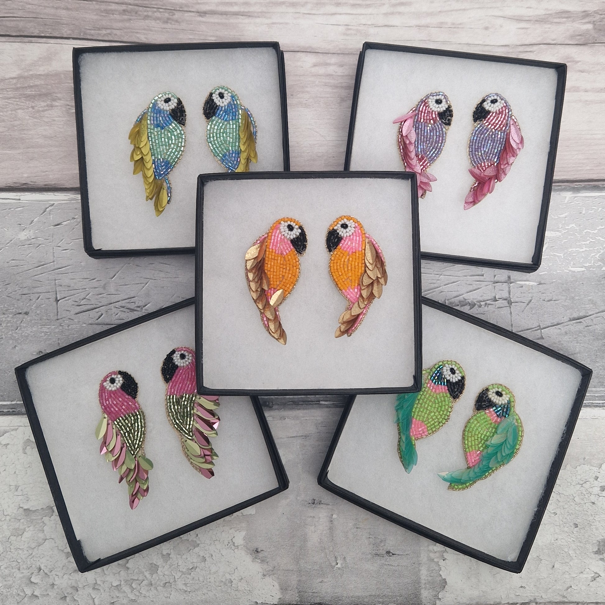5 Pairs of gift boxed brightly coloured parrot shaped earrings made from beads.