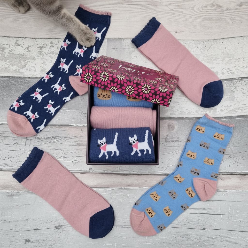 Set of colorful socks with cat patterns on a wooden surface