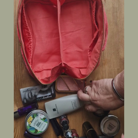Fold out vanity case being filled with make up, demonstrating how it closes up.