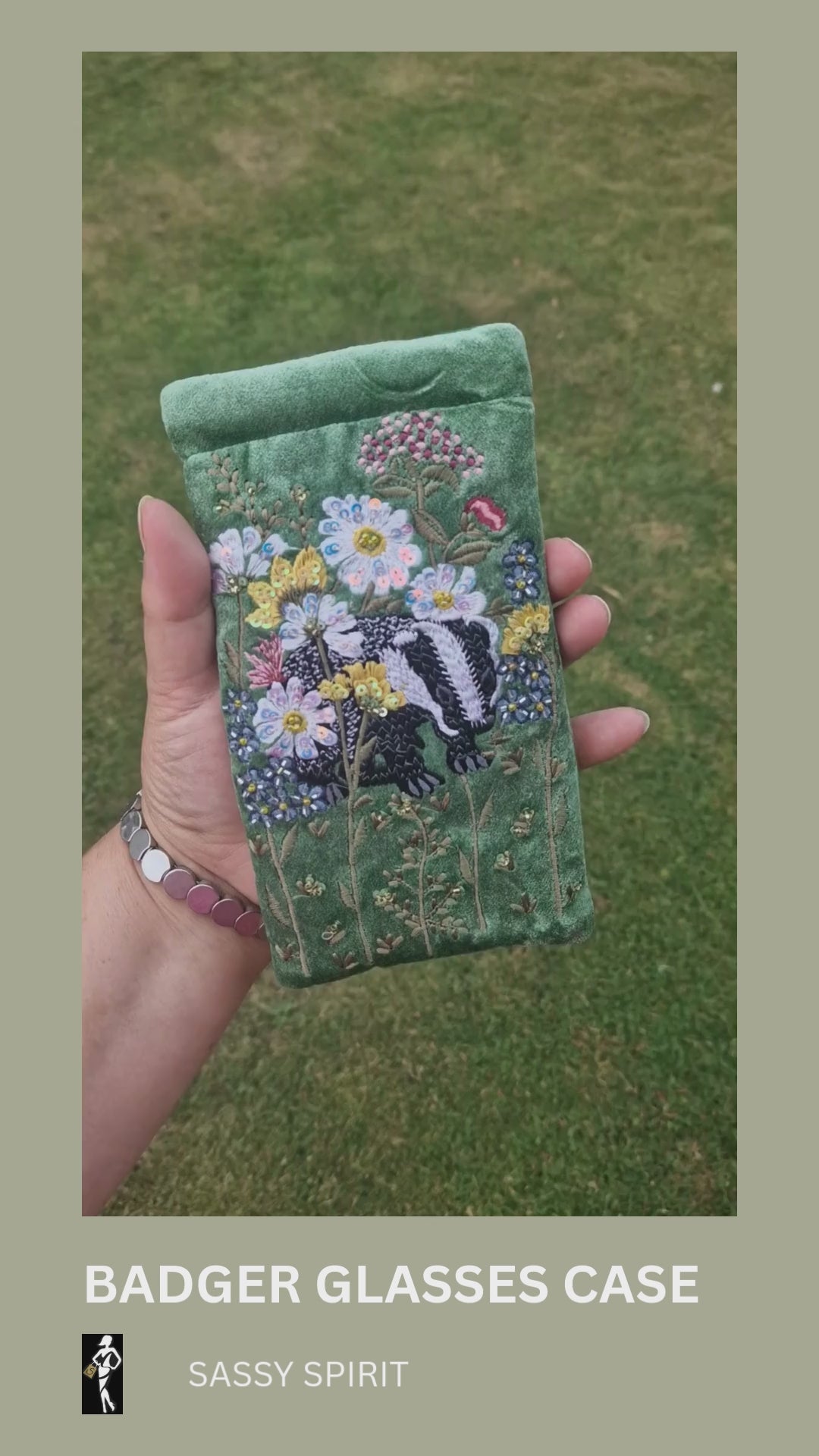 Green velvet glasses case decorated with an embroidered scene featuring a Badger in a flower garden. The scene is finished with beads and sequins.
