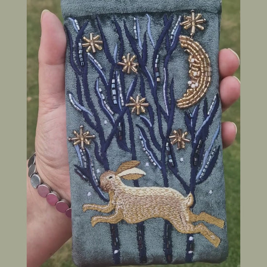 Dark grey velvet glasses case decorated with an embroidered Hare running through the woods under a crescent moon and starry night scene. Finished with beads and sequins.