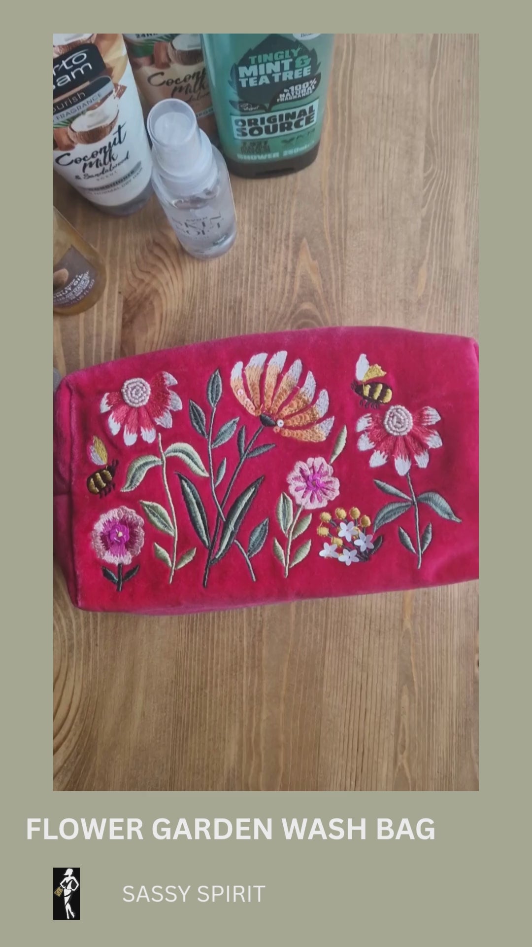 Video depicting velvet pink wash bag decorated with embroidered flower garden design being loaded with toiletries.