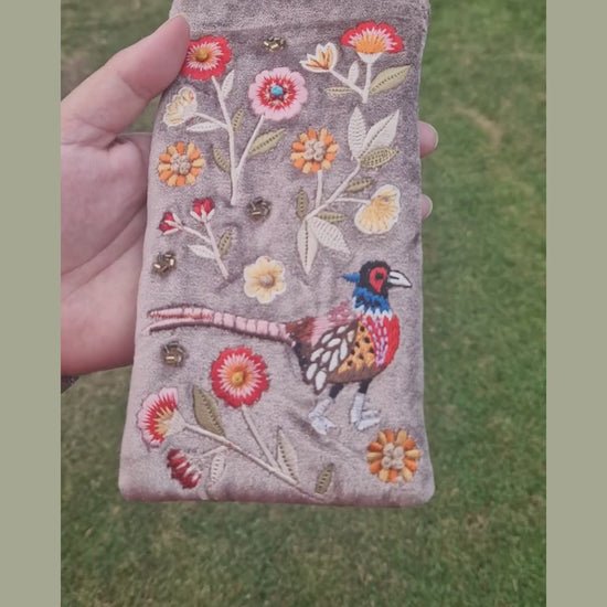 Fawn coloured velvet glasses case decorated with an embroidered scene featuring a Pheasant in a flower garden. The scene is finished with beads and sequins.