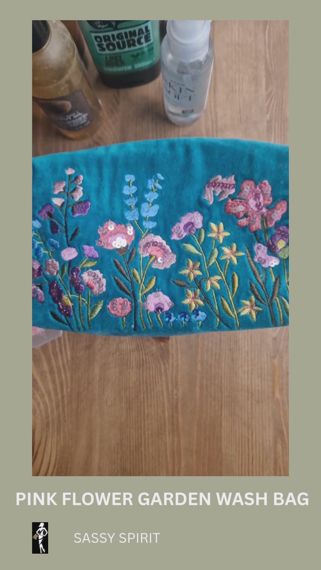 Video depicting velvet turquoise wash bag decorated with embroidered flower garden design being loaded with toiletries.