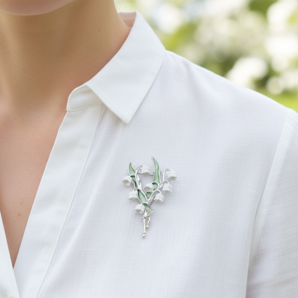 Silver lily of the valley brooch worn on white blouse