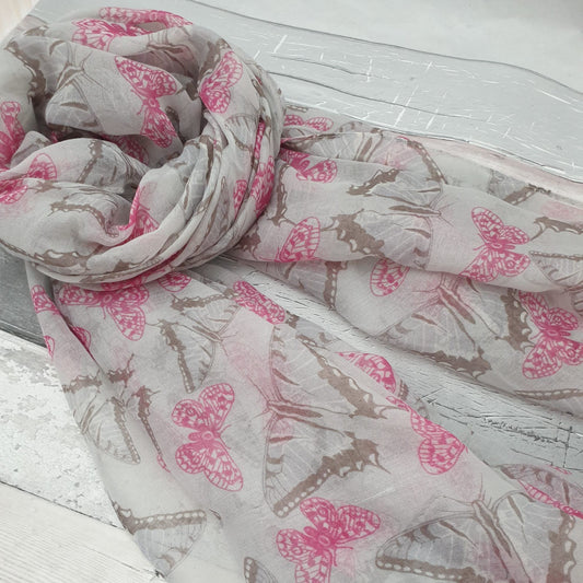 Photo of a light grey scarf covered in pink and monochrome butterflies