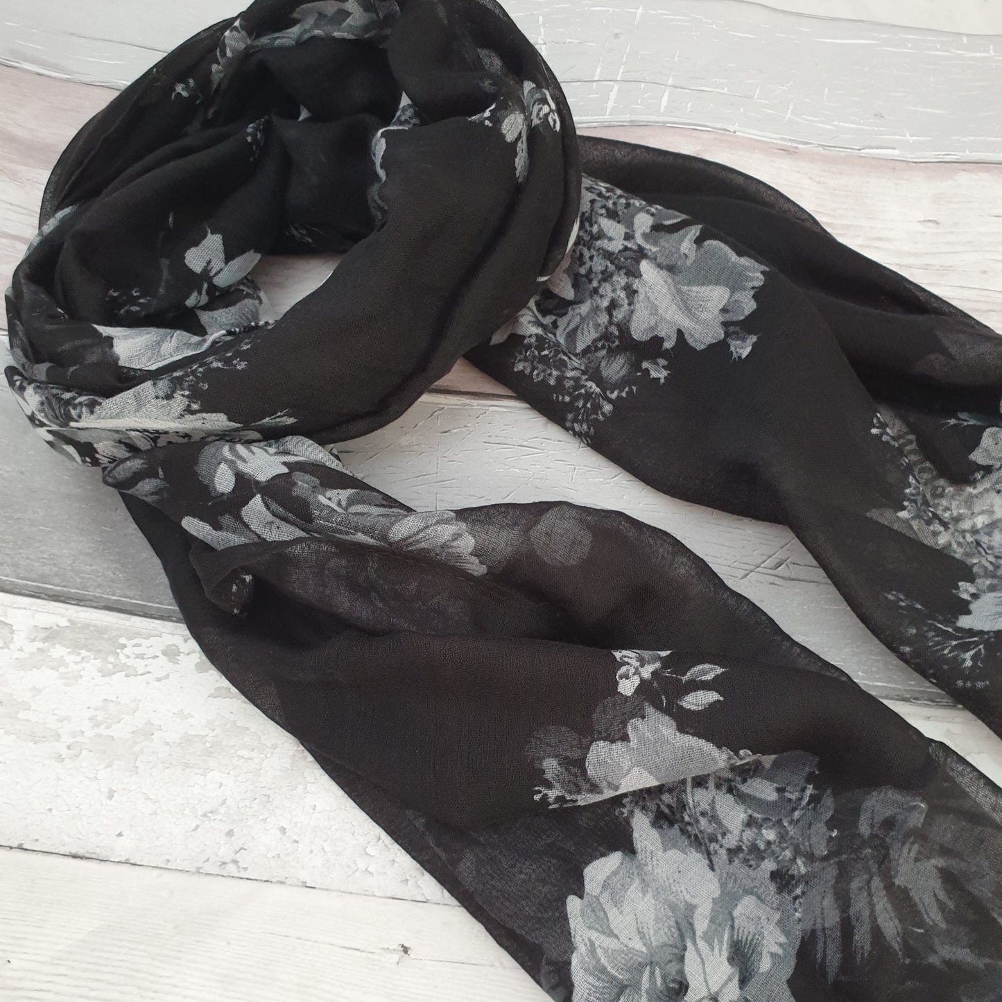 Photo of a black scarf with white rose print