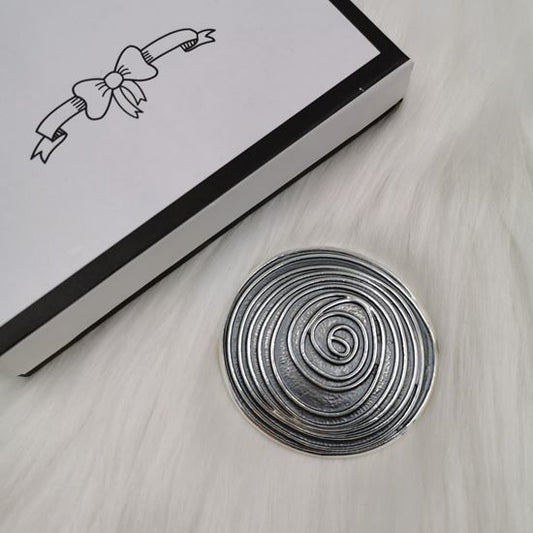 Photo of a a swirling rose pattern in an abstract style brooch