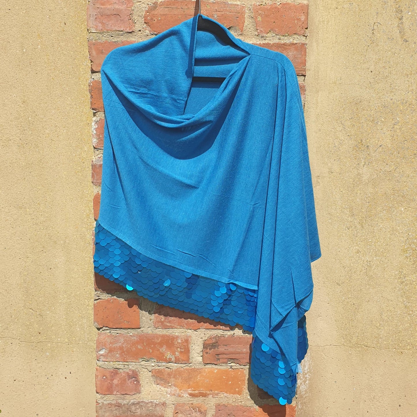Photo of a Poncho in Peacock Blue decorated with a sequin trim
