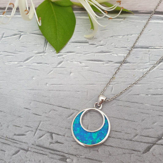 Photo of a Turquoise Blue Opalique Half Moon Pendant on a silver coloured chain
