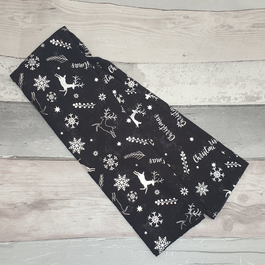 Photo of a black and silver scarf decorated with reindeer and snowflakes
