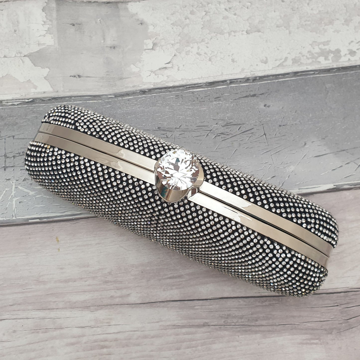 Photo of a black and silver diamante clutch bag in an unusual oblong shape with large diamante clasp