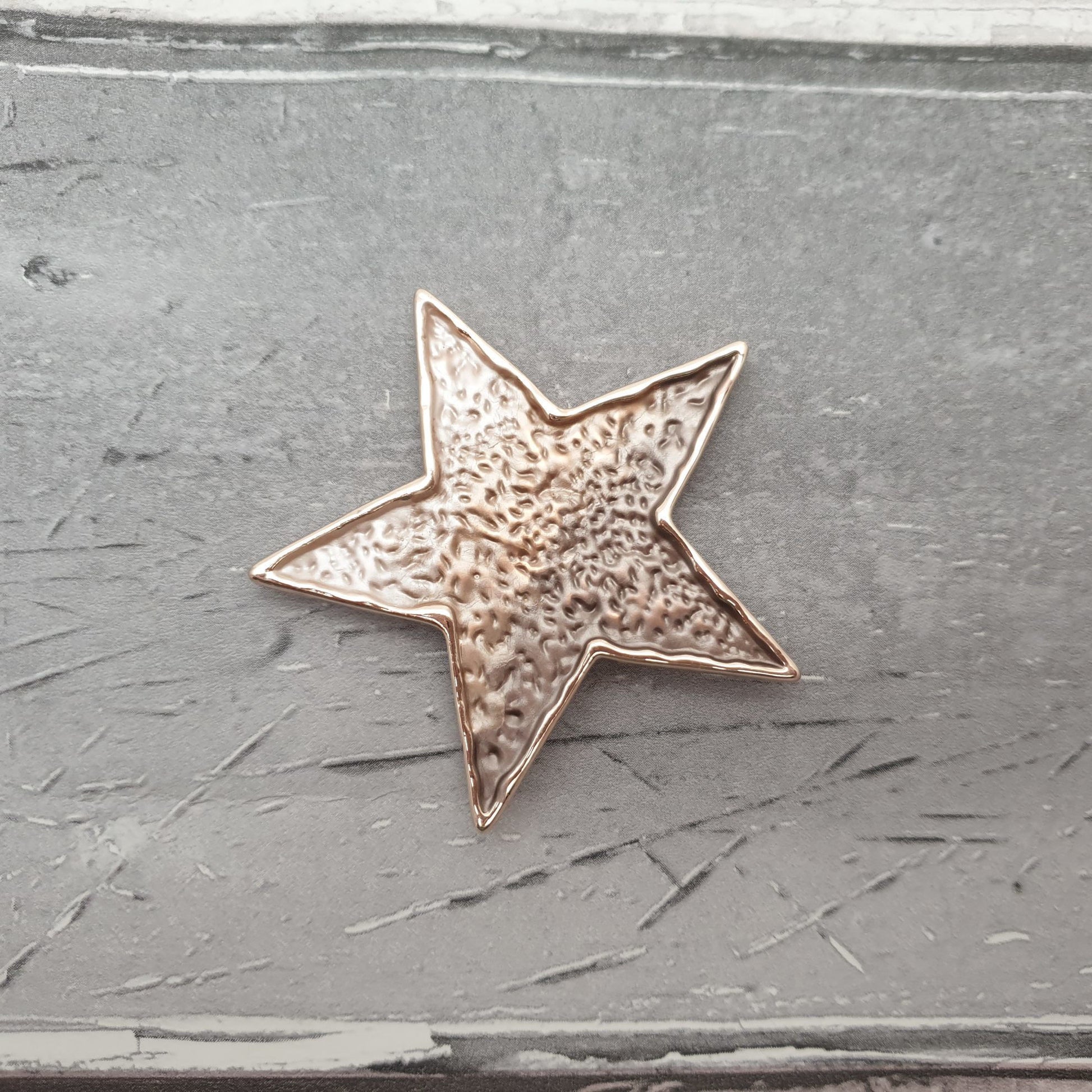 Photo of a star shaped magnetic brooch in bronze colouring