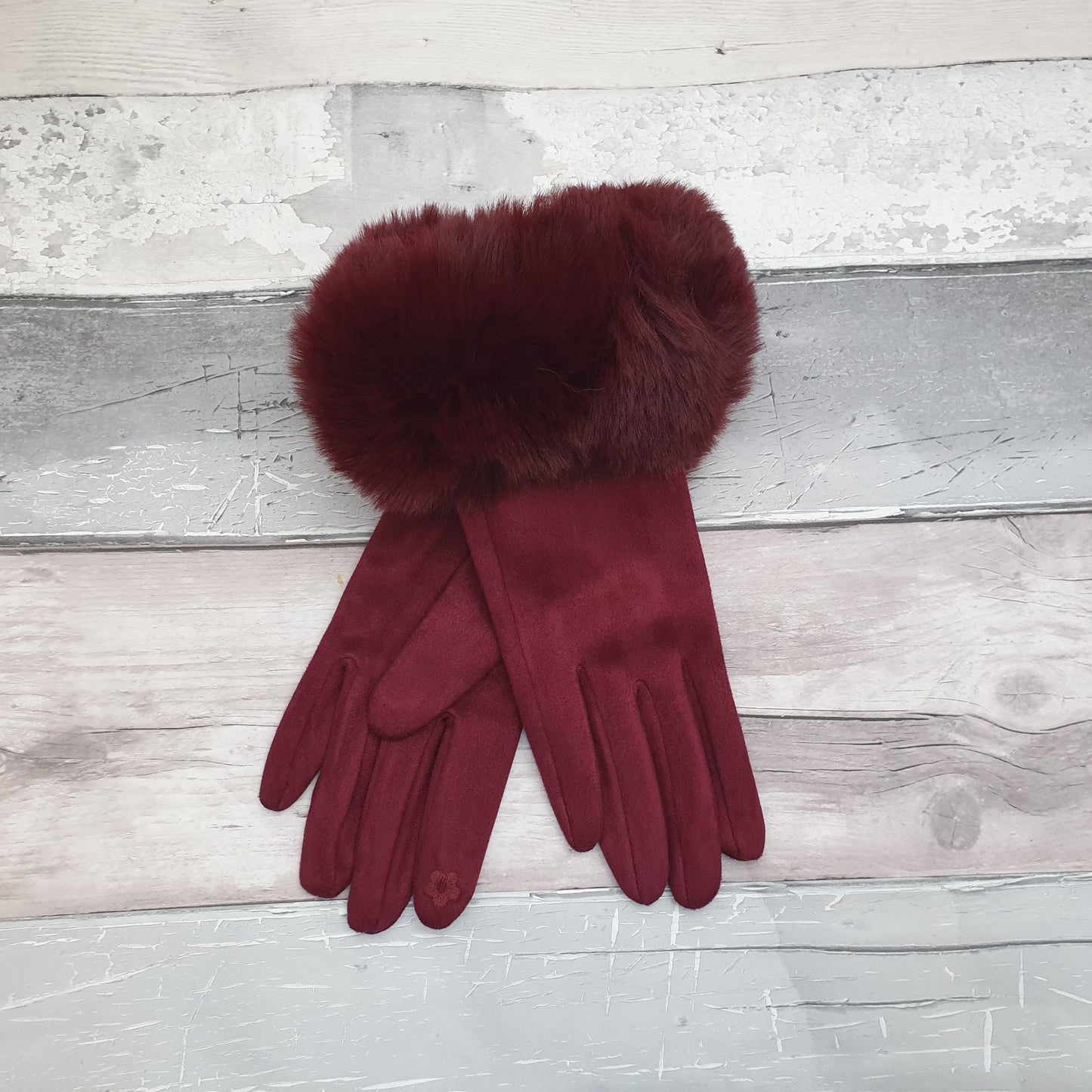 Photo of a pair of rich red wine coloured gloves with a faux fur trim