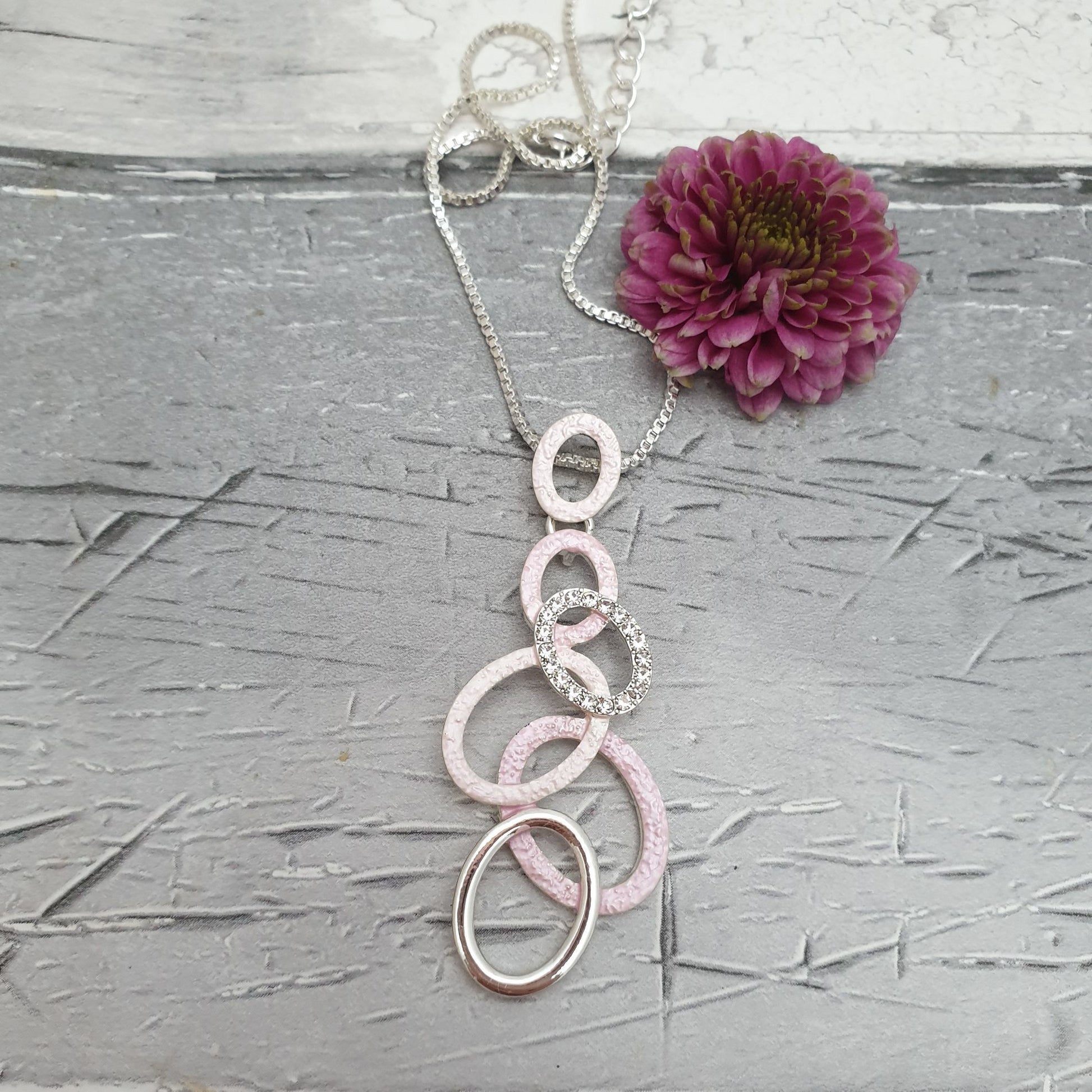 Photo of a necklace decorated with a cascade of pink and silver hoops